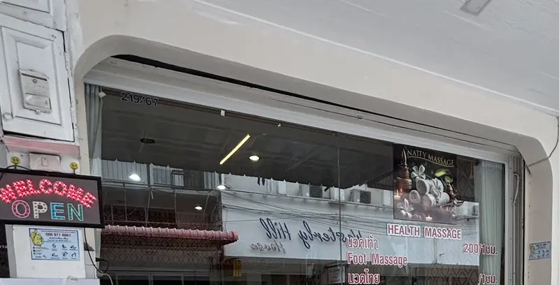 Shop front with a Welcome Open sign and the price list in the window